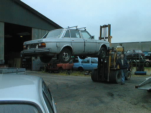 Gaffeltruck l�fter Volvo 240 p� langs